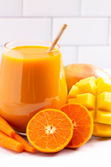 Orange Carrot and Mango Smoothie on a Bright Kitchen Cabinet