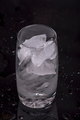 Mumbai / India 11 March 2018 glass with ice cubes on Dark background