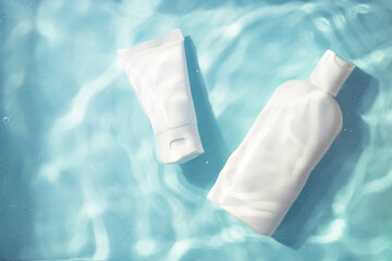 Two cosmetic bottles under water with splash. Moisturizing, reparing and skincare product.