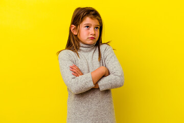 Little caucasian girl isolated on yellow background tired of a repetitive task.