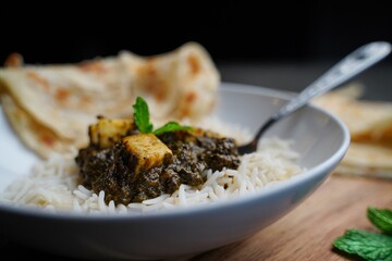 Palak Paneer or Saag Paneer-Indian cottage cheese with Spinach served with rice and roti, selective focus