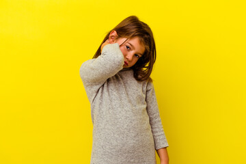 Little caucasian girl isolated on yellow background having a neck pain due to stress, massaging and...