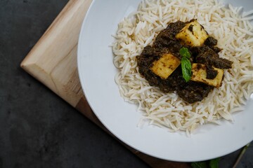 Palak Paneer or Saag Paneer-Indian cottage cheese with Spinach served with rice and roti, selective focus