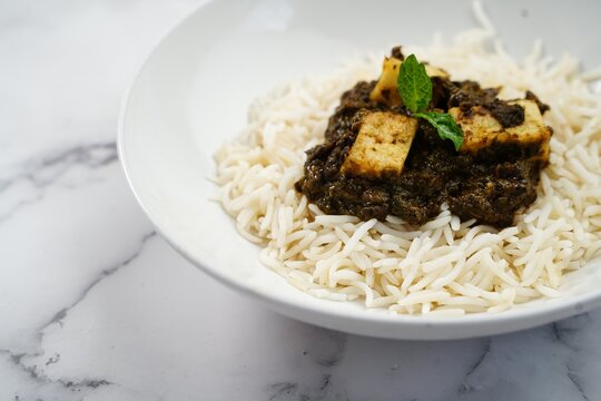 Palak Paneer or Saag Paneer with steamed basmati rice on white background