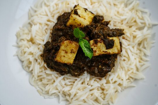 Palak Paneer or Saag Paneer with steamed basmati rice on white background