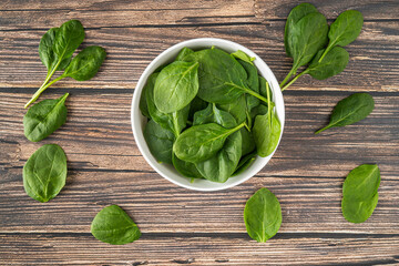 Fresh Organic Healthy Spinach Isolated in White Bowl Overhead Shot on Wood Texture Table Background with Copy Space