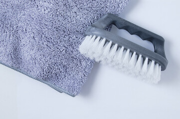 Gray household brush with stiff bristles and  rag for cleaning on a white background.