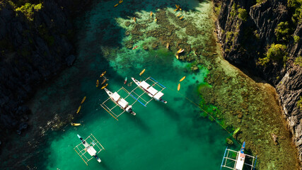 Tourists on the kayak in the lagoon with clear water, aerial view. Snorkeling and kayaking in the...