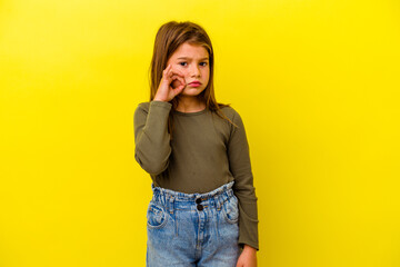 Little caucasian girl isolated on yellow background with fingers on lips keeping a secret.