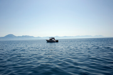 Beautiful seascape with a yacht anchored offshore in a cobalt blue sea. Fishing.