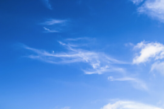 Defocused slice of the July sky. On a warm summer day, soft clouds and the Moon met in a bright blue sky. Natural beauty. Russia