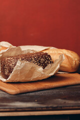 loaf of bread on a board baking flour product and red background