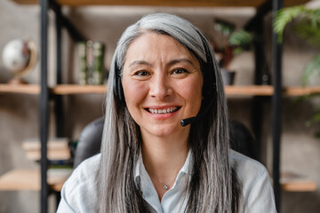 Successful mature grey-haired woman working as a it-support in call centre