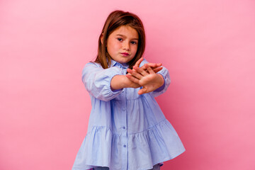 Little caucasian girl isolated on pink background  doing a denial gesture