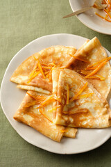 Crepes suzette with orange sauce and zest.