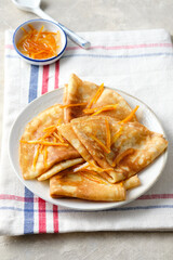 Crepes suzette with orange sauce and zest.