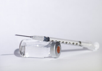 a vial containing clear fluid is shown with a syringe
