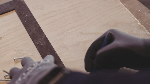 Carpenter Using T-Square On Wood