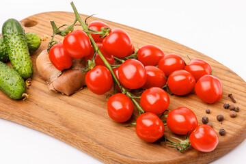 Branch of red tomatoes on a wooden kitchen board