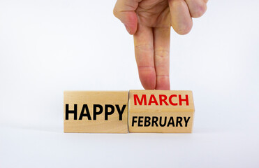 Symbol for the change from February to March. Businessman turns wooden cubes and changes words 'Happy February' to 'Happy March'. Beautiful white background, copy space. Happy March concept.
