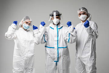 Three healthcare workers make win gesture wearing in hazard on white background
