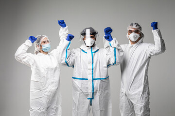 Three healthcare workers make win gesture wearing in hazard on white background