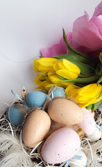 Spring composition of yellow tulips and Easter eggs