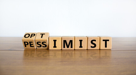 Pessimist or optimist symbol. Turned cubes and changed the word 'pessimist' to 'optimist'. Beautiful wooden table, white background. Business and optimist or pessimist concept. Copy space. - obrazy, fototapety, plakaty