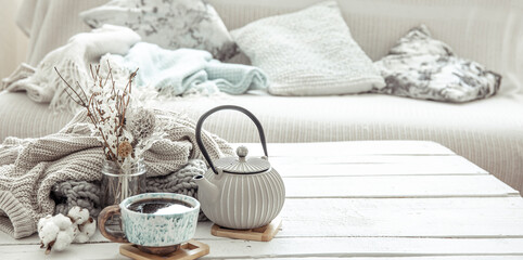 Fototapeta na wymiar Cozy Scandinavian composition with teapot, ceramic cup of tea and decor details copy space.