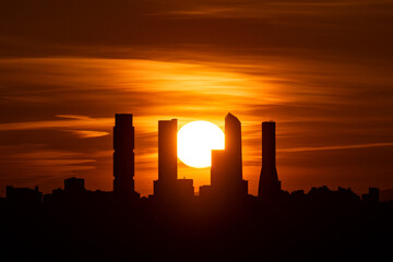 Sunset behind the skyline with the Four Towers Business Area (CTBA) skyscrapers of Madrid, Spain.