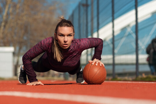  Sporty woman exercising with ball outdoor - Powered by Adobe