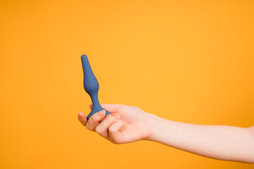 Adult sex toys, butt plug on an orange background. Anal dildo, butt plug in paper bag. 