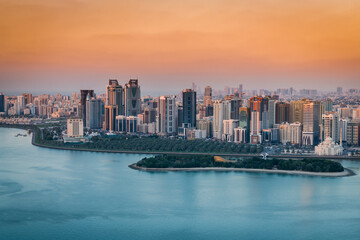 Sunset of a cityscape in urban city with red and blue contrast at sunset with a lake water view 
