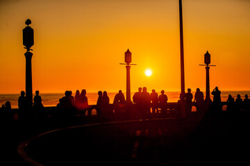 Crowd of people watching sunset at the turnaround at Seaside, Oregon.  Historically the Turnaround is where Lewis & Clark ended their journey. Crowd of people watching sunset.