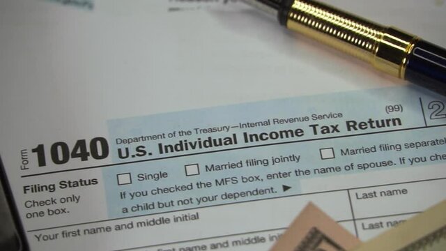 Blank Form 1040 U.S. Individual Income Tax Return with Pen and banknotes