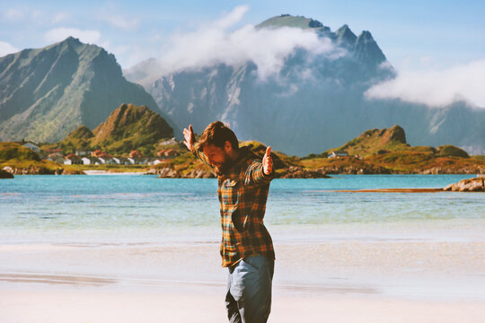 Mental health outdoor man traveler hands raised enjoying nature view active healthy lifestyle adventure vacations in Norway happy emotions harmony concept