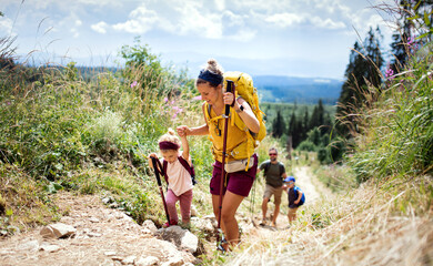 Family with small children hiking outdoors in summer nature, walking in High Tatras. - obrazy, fototapety, plakaty
