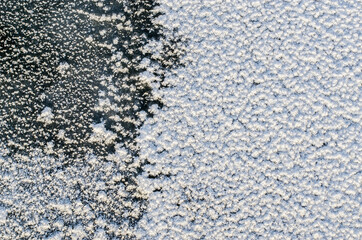 Two-color mosaic texture of frozen river water surface.