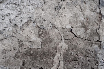 Textured background from old wall, damaged concrete slab material, crumbled surface with yellowed moss, uneven texture.