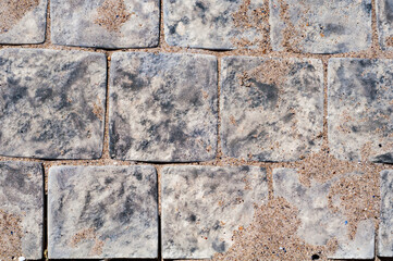 Background from paving marble tiles, yellow sand, textured background.