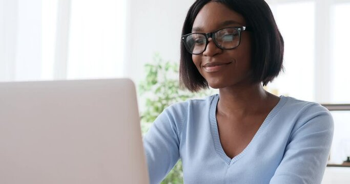 Smiling woman working on laptop at home office