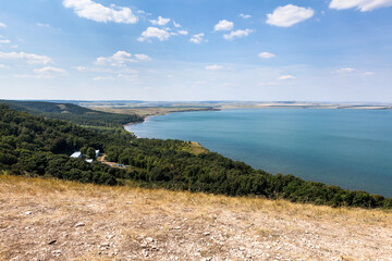 Fototapeta na wymiar Hills and shore of the Aslikul lake with children summer camp. The Republic of Bashkortostan, Russia