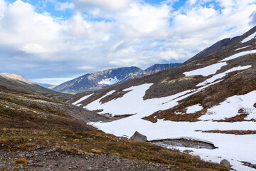 A mountain pass with lot of snow in northern mountains. Snowy slopes of the Khibins range, Kola peninsula, Russia