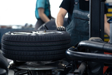 Car mechanic changing tires of a car in a repair shop,car garage (shallow DOF, colour toned image)