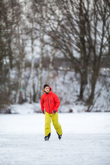 Young man ice skating outdoors on a pond on a freezing winter day