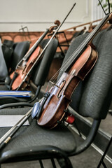 Violins stand on empty chairs of the concert hall before the start of the symphony concert.