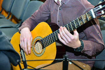The guy plays the guitar in the concert hall.