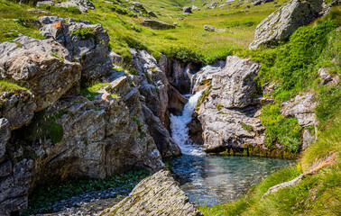 Beautiful waterfall with crystal clear water in a green meadow in summertime