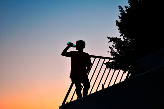 Silhouette eines trinkenden Jungen