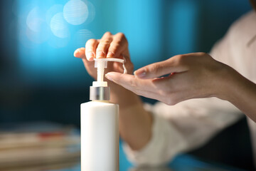 Woman hands applying moisturizer cream in the night